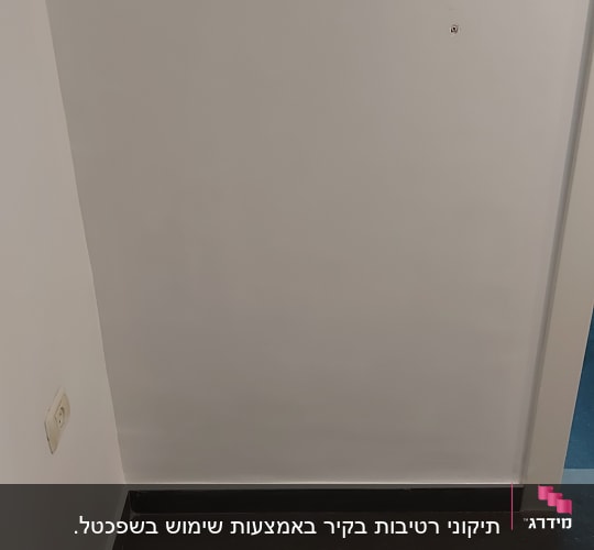 קיר צבוע בלבן עם חורים קטנים